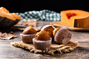 Pumpkin muffins on rustic wooden table. Autumn dessert