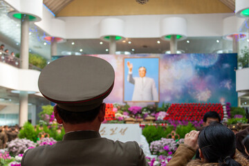 Back view of North Korean soldiers staring at Kim Il Sung portrait