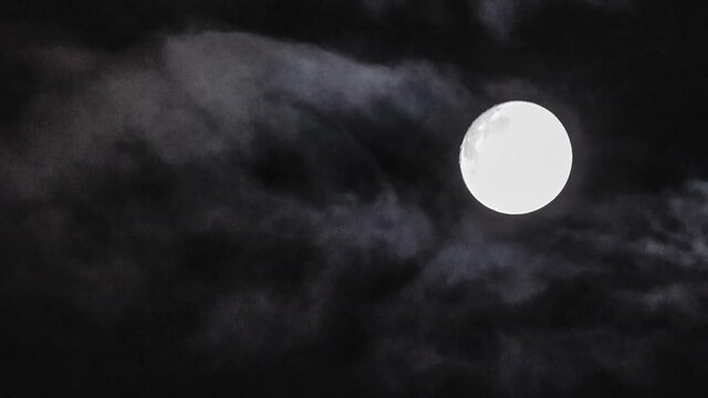 Timelapse fof full moon with clouds on black sky