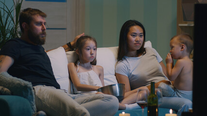 Parents with kids watching TV