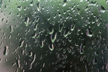 water droplets on glass with nature green background