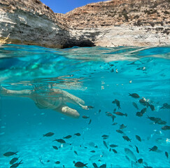 Fototapeta premium ragazza fa snorkeling nel mare di lampedusa