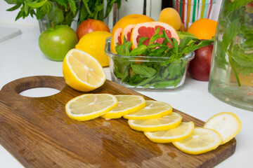on a wooden board, a juicy yellow lemon is cut into slices, for making a refreshing drink