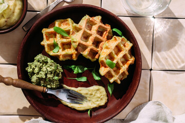 Belgian zucchini waffles with sauce on a light background