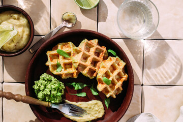 Belgian zucchini waffles with sauce on a light background