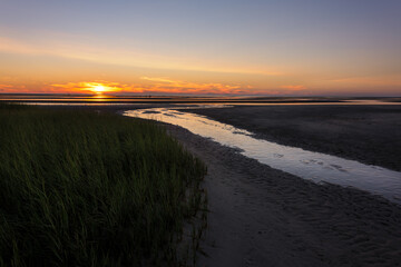 A sunset photograph on a beach during low tide
