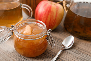 Delicious apple jam in jar on wooden table