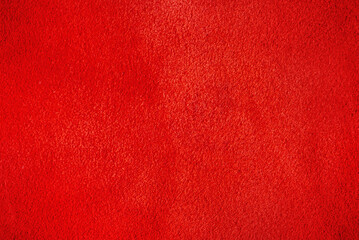 Macro photo of red suede leather. The texture is velvet red.
