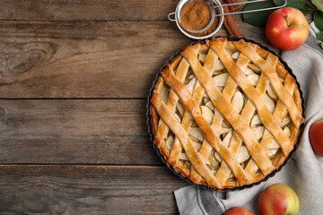 Delicious traditional apple pie on wooden table, flat lay. Space for text