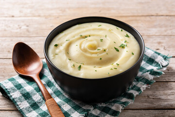 Mashed potatoes in a bowl on wooden table