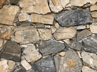 Old ancient wall with different stones as abstract background