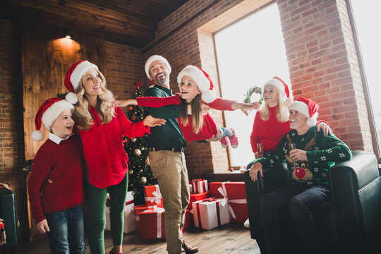 Photo portrait of daddy playing with daughter near grandparents drinking champagne on christmas laughing together