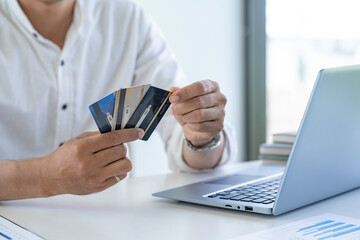 Business man choosing the right credit card for online spending, Online payment, man hands holding a credit card and using smartphone and choose some product what for online shopping.