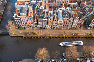 Canal Boat Passing in front of Waterfront Properties in Amsterdam