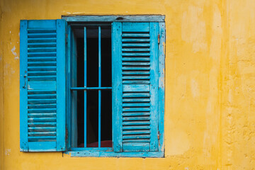 Blue window on the yellow antique wall with copyspace