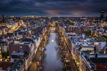Amsterdam City Canals at Night with a Tour Boat Aerial View
