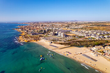Playa Mil Palmeras drone point of view. Aerial photography sandy beach and Mediterranean Sea at sunny summer day. Travel destinations and tourism concept. Spain, Costa Blanca, Alicante Province. Spain