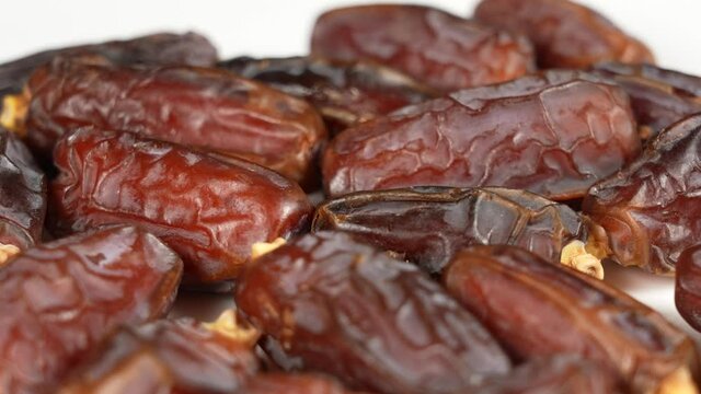 Close-up view 4K stock video footage of tasty brown dried dates fruit isolated on white background