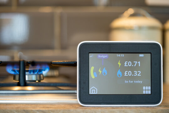 selected focus household digital smart meter against a background of a gas flame on a cooker .