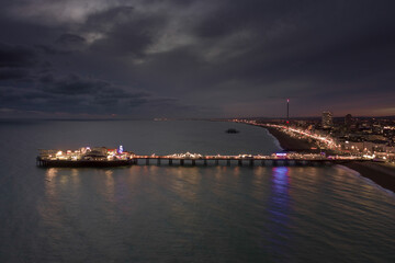 The Seafront Palace Pier in Brighton Illuminated at Night Aerial View