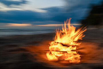 Fire flames burning on the beach at night