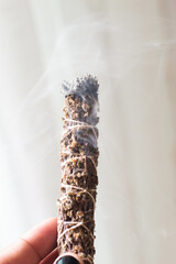 A close up image of a burning incense stick and smoke from incense burning. Beautiful smoke. Stick used for energy clearing and healing. White sage.