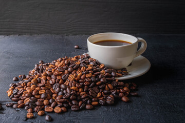 coffee cup and roasted coffee beans on black background