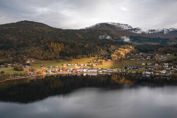 Fototapeta na wymiar Small Town on the Shores of a Fjord in Norway Reflected in the Waters