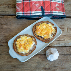 Pita baked with cheese and mushrooms  on wood deck.