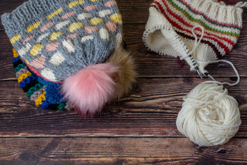 pile of knitting hand made pompom hats 