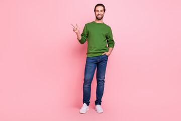 Full length portrait of glad person direct finger empty space proposition isolated on pink color background