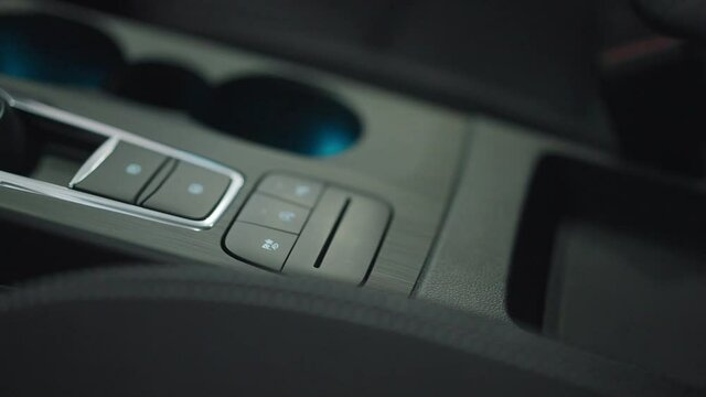 Close-up black car control panel with buttons inside automobile. Luxurious interiors of expensive vehicle part in dealership. Auto industry and advertising concept