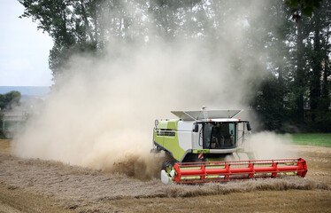 Dusty wheat harvest with a big machine