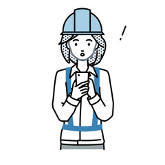 立ってスマートフォンを操作して何かに気づいて驚いた工事現場の女性