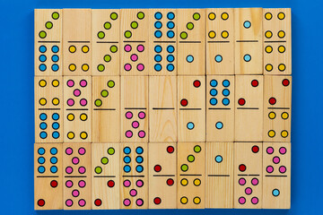 Top view of wooden dominoes gaming pieces as background on the blue background