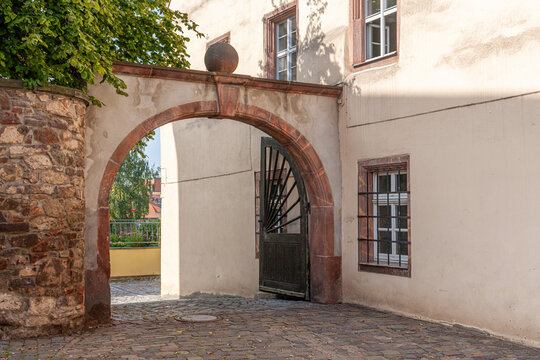archway with sandstone elements in the old town of Colditz, Saxony in Germany. Path with cobblestones and old house with mullioned windows