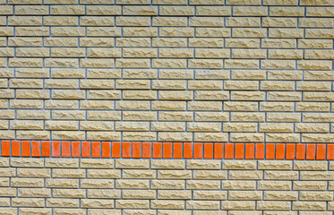A stone wall with a red brick insert.
