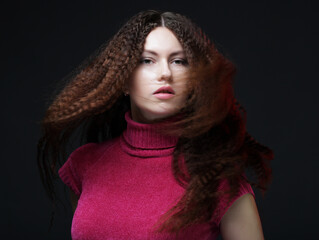 Young happy woman with wind in hair. Studio shot.