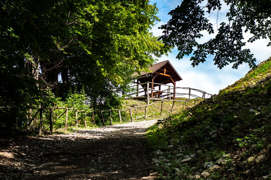 Hiking trail with railings leading to a wooden gazebo for a relaxing picnic or recreation in beautiful forest nature