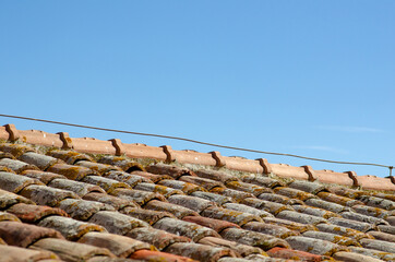 House: building with roof tiles and brick tiles, visible lifeline and upper pitch with ridge tiles.
