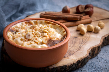 Baked rice pudding turkish milky dessert sutlac in earthenware casserole with hazelnuts