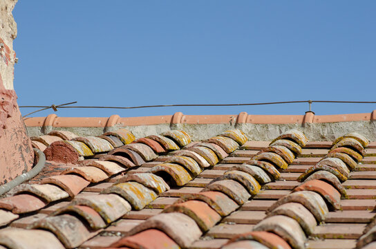 House, gabled roofs with tiles, upper ridge and exposed ridge tiles. The tiles are made of earthenware or terracotta, an ancient design of curved and flat tiles that form rainwater drains on a roof.