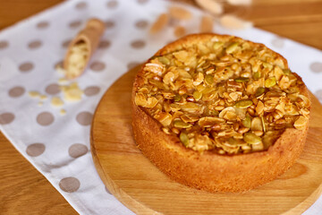 Apple or pear pie, tart with caramel nuts on wooden table, copy space, top view.