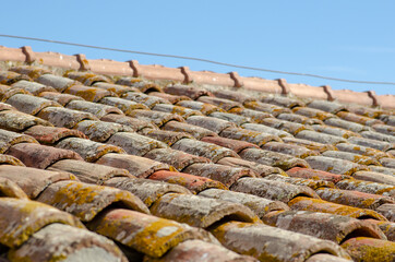 House, gabled roofs with tiles, upper ridge and exposed ridge tiles. The tiles are made of earthenware or terracotta, an ancient design of curved and flat tiles that form rainwater drains on a roof.
