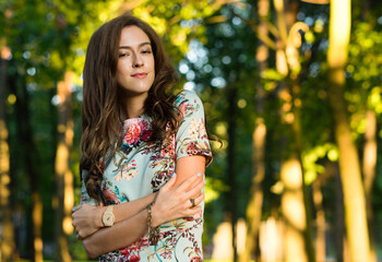 Beautiful young fashion woman outdoors. Romantic model in summer outfit in golden field at Sunset.