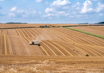 Crop havesting with combine and tractor on a dry sunny day