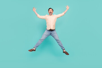 Full length photo of hooray mature man jump wear shirt jeans sneakers isolated on teal color background