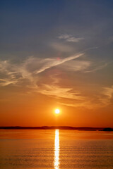 Evening sunset over the lake in orange tones. Evening sunset over the water. Sunset scene.