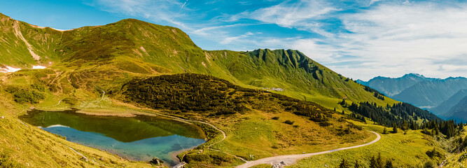High resolution stitched panorama of a beautiful alpine summer view with reflections in a lake at the famous Fellhorn summit near Oberstdorf, Bavaria, Germany
