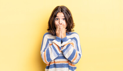 young pretty girl happy and excited, surprised and amazed covering mouth with hands, giggling with...